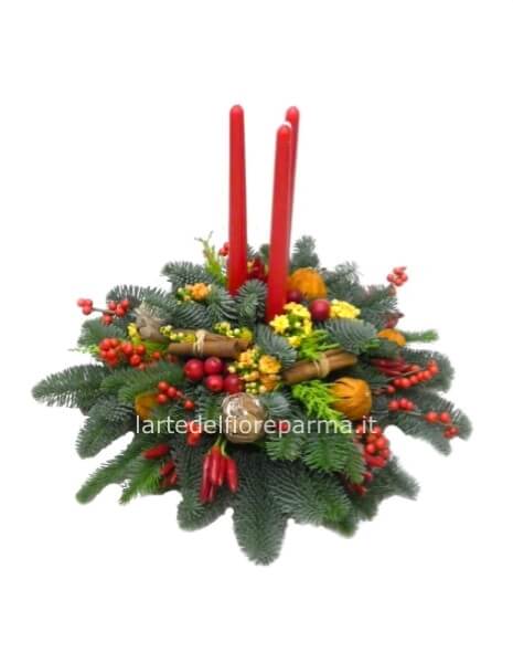 Composizione natalizia con fiori rossi e bianchi, candele e abete con altri decori